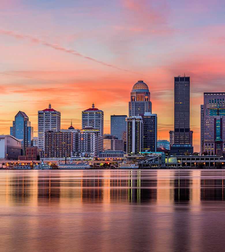 Louisville skyline at sunset with reflective buildings in the water, a prime location for personal injury lawyers.