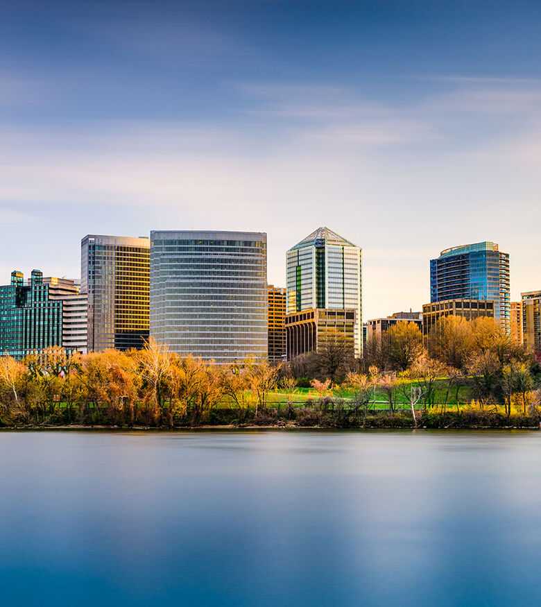 Autumnal colors frame the Arlington skyline reflecting on a river, a scenic locale for personal injury lawyers.
