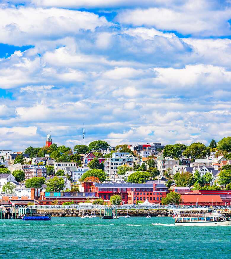 Scenic view of Portland, Maine coastline with colorful buildings and bustling harbor on a sunny day