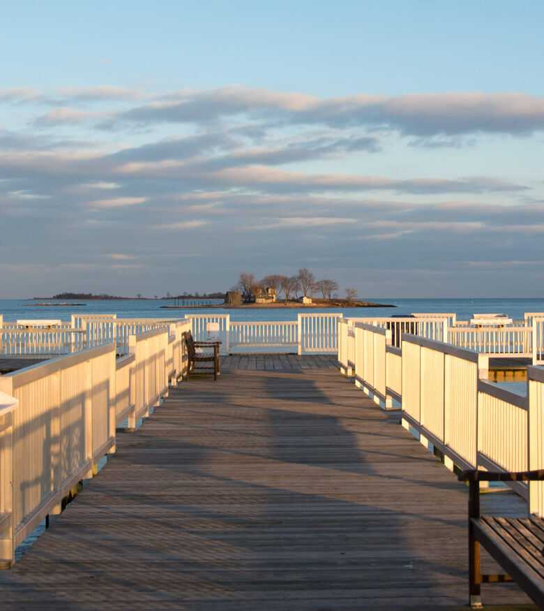 Wooden pier extending into a calm sea at sunrise in Norwalk, a serene location for personal injury lawyers.