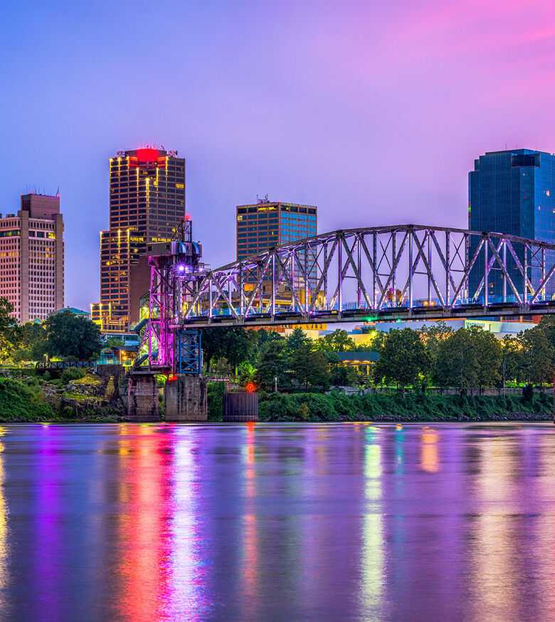 Vivid sunset over Little Rock skyline and river, highlighting the city's appeal for personal injury lawyers.