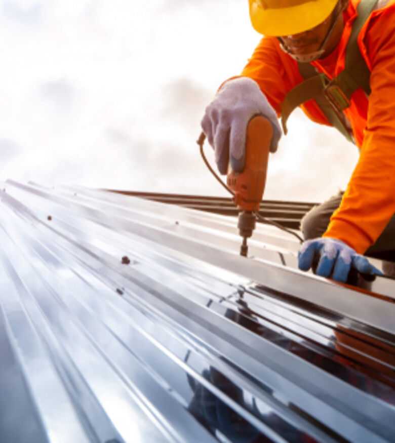 Construction worker securing metal roofing