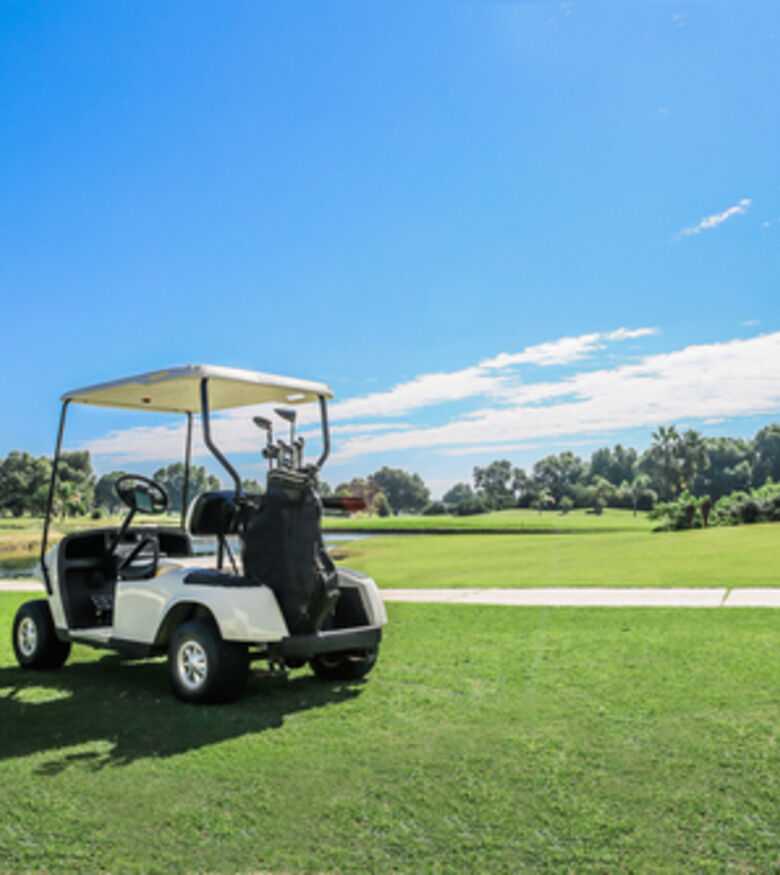 Golf cart on a sunny golf course with clear blue skies