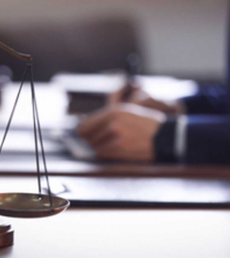 Scales of justice on a lawyer's desk with blurred background