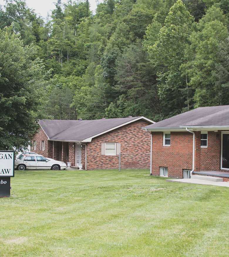 Quiet residential area in Prestonsburg with brick homes and lush green lawns, suitable for Personal Injury Lawyers.