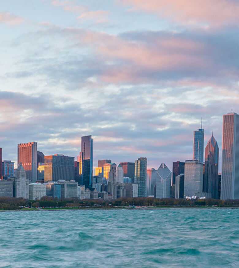 Dusk view of Chicago's skyline with vibrant pink clouds reflected in Lake Michigan, prime for Personal Injury Lawyers.