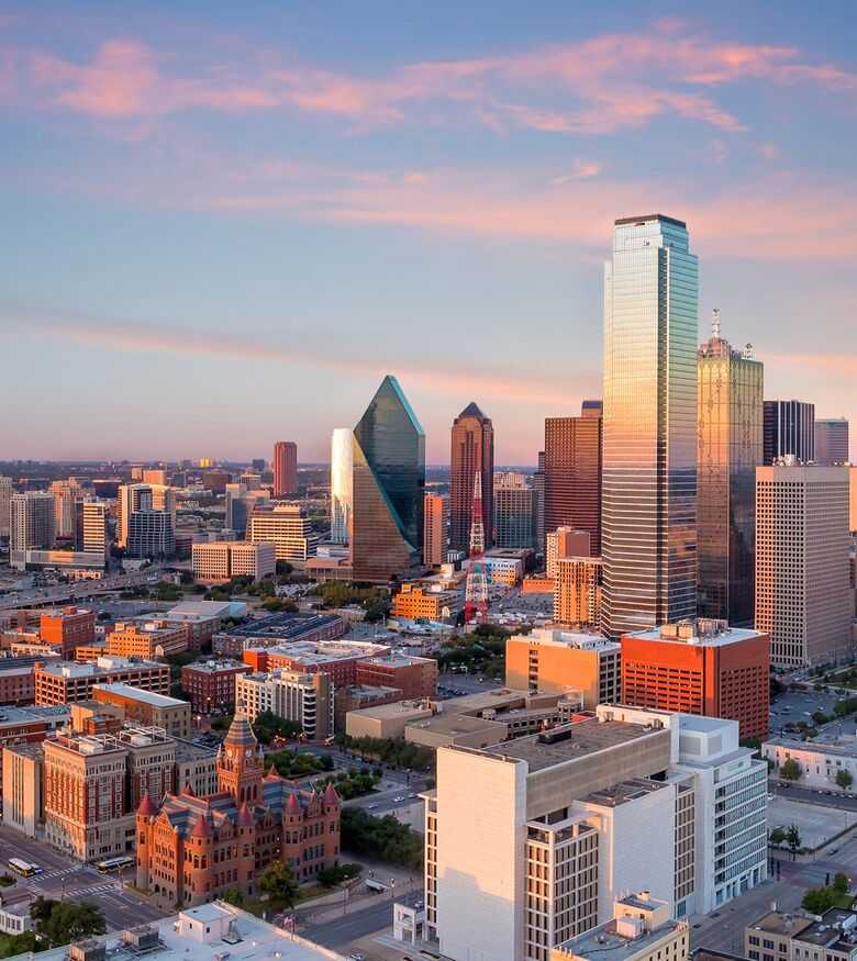 Sunset over Dallas skyline showing dense buildings and colorful sky, a thriving scene for Personal Injury Lawyers.